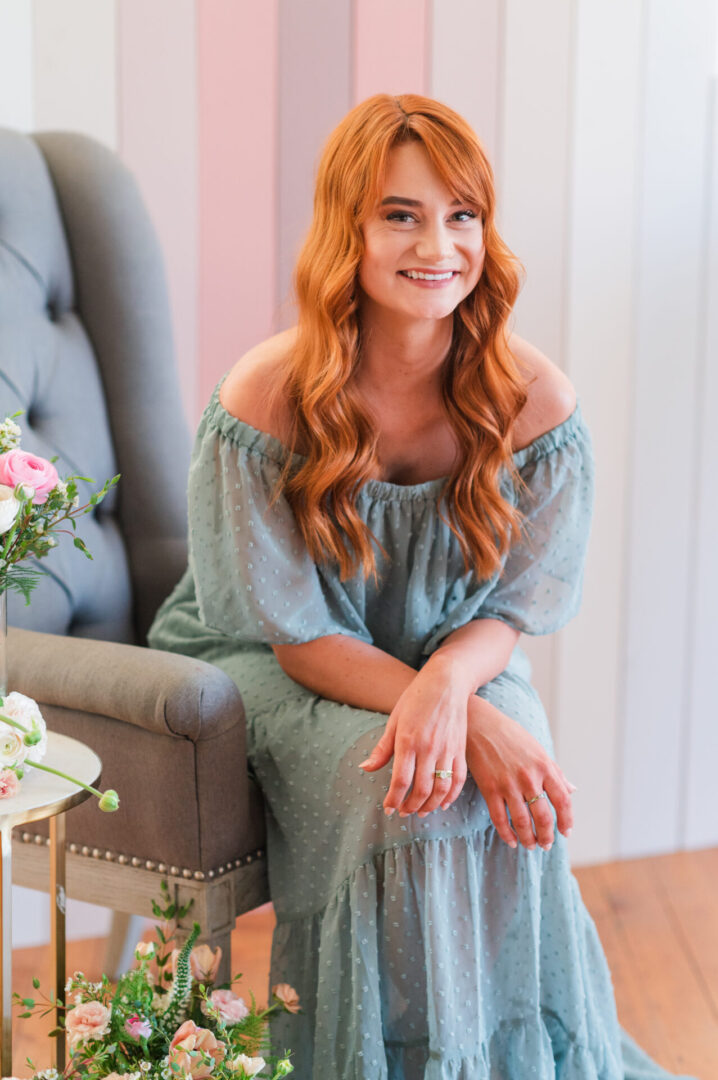 A woman sitting on the chair in front of a table.